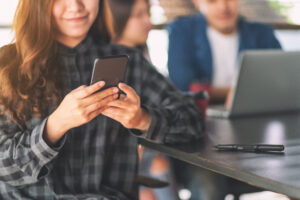 A beautiful asian woman using and looking at mobile phone with c